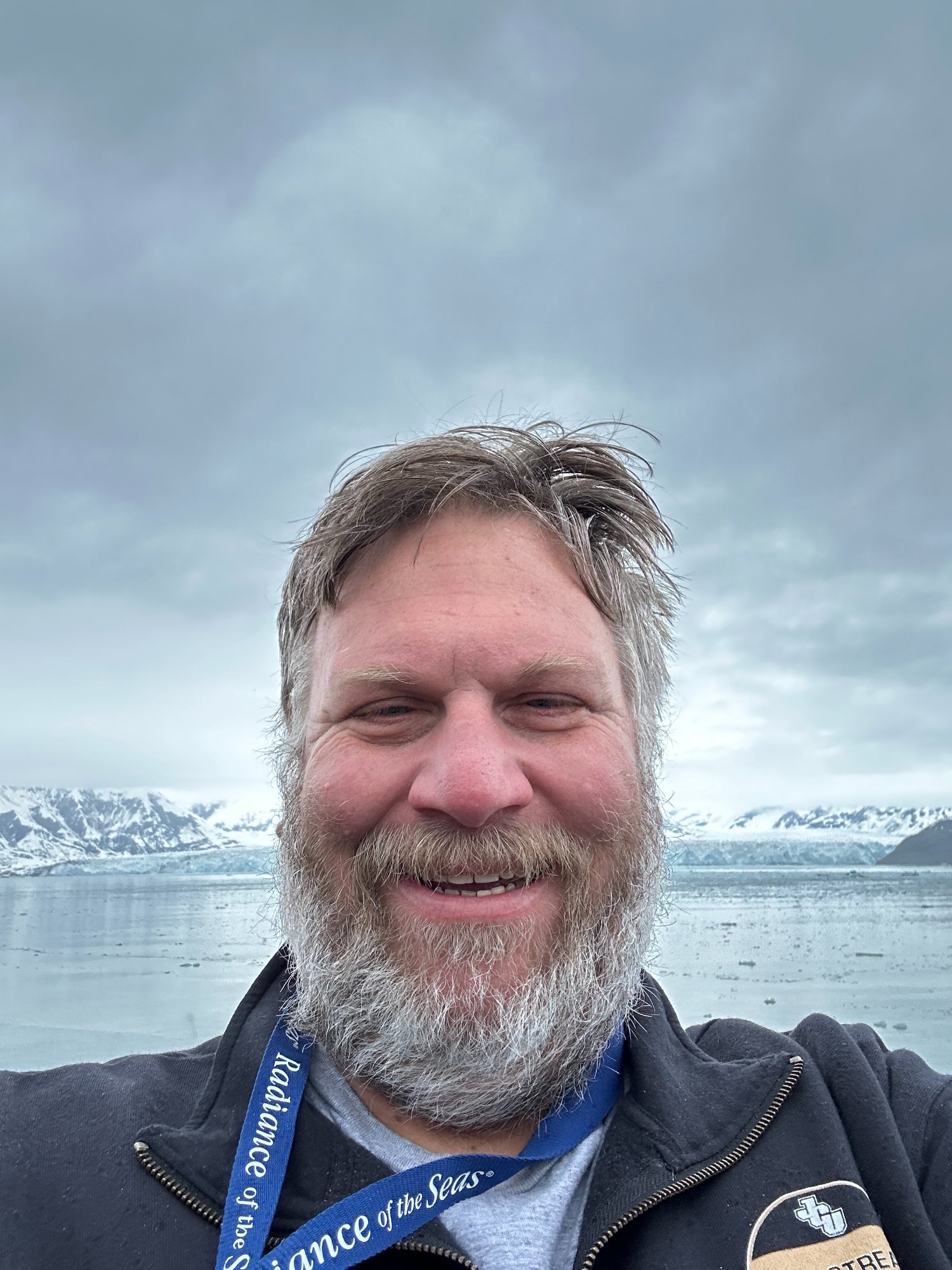 Cruise ship sailing through an Alaska fjord with snow-capped mountains